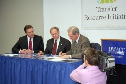 photo of Ron Troyer with DMACC and Grand View presidents signing agreement