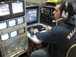 photo of Eric Michel directing scoreboard crew at men's basketball game