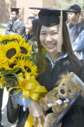 Graduate holding sunflowers.