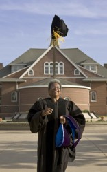photo of Deb Turner tossing cap in air after graduation