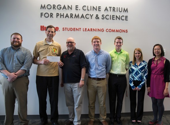 Professor John Rovers, third from left, and Drake students deliver a $4,700 check to Medicine for Mali President Dave Merschman, second from left, on May 8.