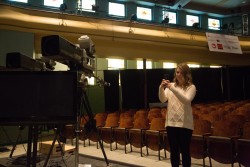 Samantha Ohlson photographs the set of the Iowa Brown and Black Presidential Forum in Sheslow Auditorium, where the three Democratic presidential candidates would later take the stage.