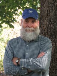 Portrait of Tom Rosburg standing beside a tree