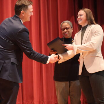 students shakes hand and accepts award