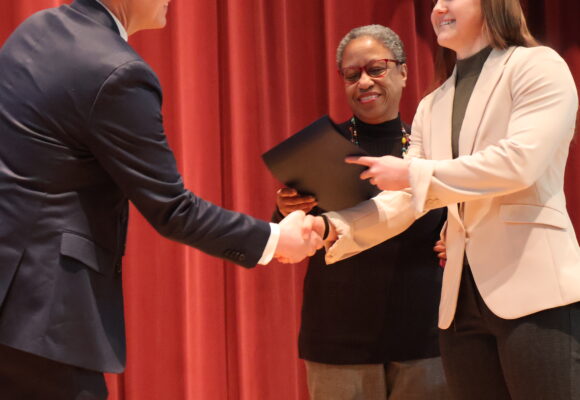 students shakes hand and accepts award