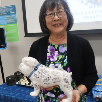 Yolanda Griffiths at retirement party holding bulldog statue signed by colleagues