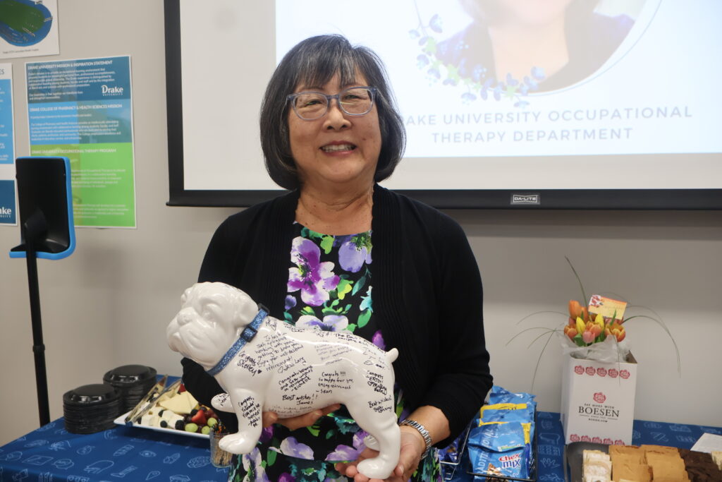 Yolanda Griffiths holding signed bulldog at retirement party