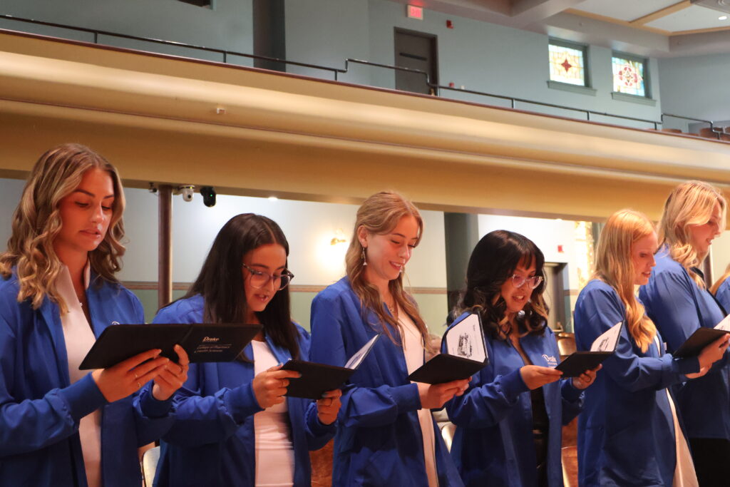 OT students read Oath together wearing blue coats