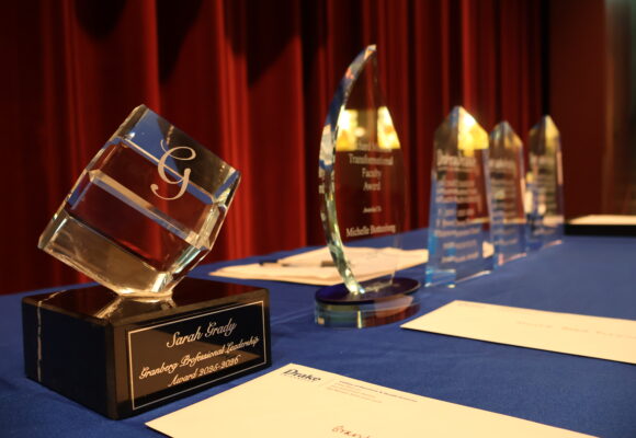 Faculty awards sitting on table on a stage