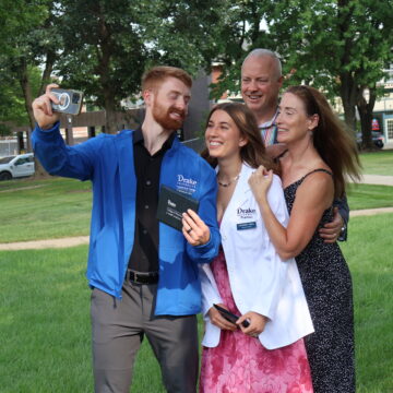 IMG_7546 An OT and Pharmacy student take a selfie together with their family wearing blue and white coats